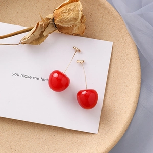 Boucles d'oreilles cerises rouges avec crochets dorés sur une carte de présentation