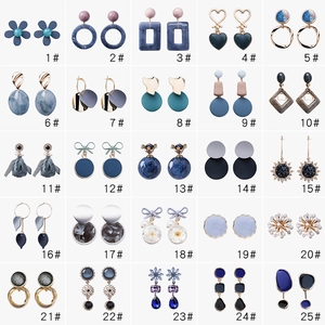 Macro display of 25 pairs of minimalist blue and grey geometric earrings in various styles