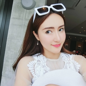 Close-up of golden teardrop pendant earring and elegant white hollow lace top