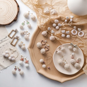 Collection d'hiver de boucles d'oreilles pompons en peluche beige et crème pour femmes