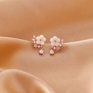Detail view of shell flower earrings with pear-cut cubic zirconia and rose gold plating
