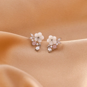 Macro shot of shell flower earrings with pink and pear-shaped zircon details