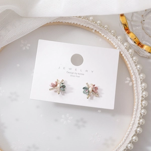 Petite floral stud earrings with pink matte petals and pearls on a jewelry card