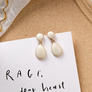 Détails des boucles d'oreilles goutte en émail crème avec bordure en métal doré