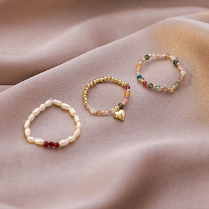 Three-piece set of boho beaded stretch rings with pearls, gemstones, and gold heart charm
