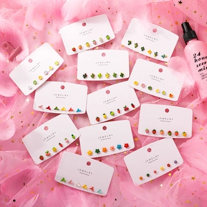 Flat lay of colorful 925 silver stud earring sets with fruit and flower charms