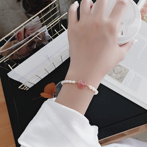 Baroque freshwater pearl bracelet with pink heart crystal shown in an elegant lifestyle setting