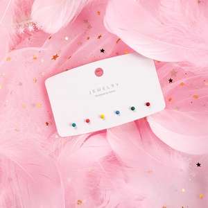 Close-up of 6-piece colorful round bead stud earrings set on a white jewelry display card