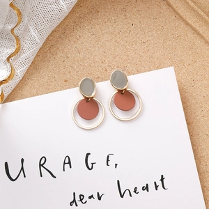 Détails de boucles d'oreilles géométriques en acrylique gris et orange avec cadre doré