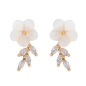 Detailed macro view of shell flower earrings with marquise-cut leaf zircons on gold alloy
