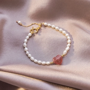 Detail of freshwater pearl bracelet with strawberry quartz heart and gold OT clasp