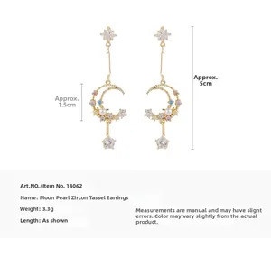 Detail of moon tassel earrings with pearls and colored zirconias on white background