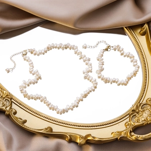 Gros plan d'un collier en perles d'eau douce baroques sur un miroir doré vintage