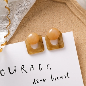 Détail de perles ambrées vintage et boucles d'oreilles en résine marbrée marron
