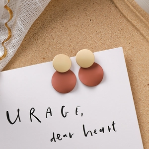 Détail de boucles d'oreilles pendantes géométriques rondes marron mat et dorées