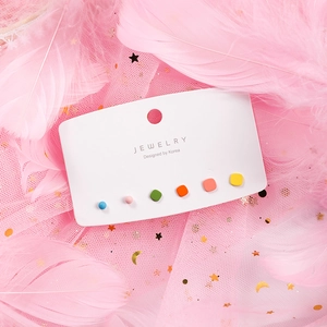 Detail of 6-piece colorful ceramic stud earrings set on a white jewelry display card