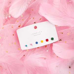 Close-up of 6-piece matte colorful geometric stud earrings set on a white display card