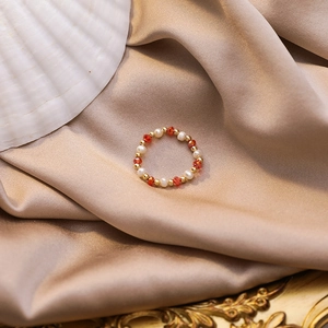 Detailed close-up of handmade beaded ring with fresh water pearls and orange crystal beads