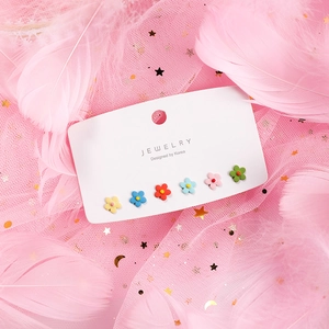 Close-up of 6 pairs of colorful matte flower stud earrings on a display card
