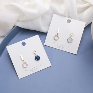Detail of 925 silver post earrings featuring blue starry discs and crystal accents