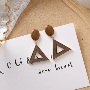 Gros plan sur des boucles d'oreilles vintage en acrylique marron et bordure dorée