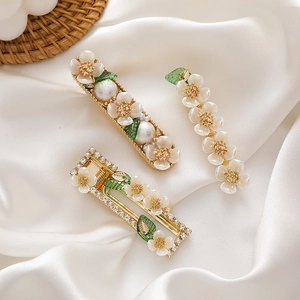 Three-piece floral hair clip set with shell flowers pearl beads and green leaves