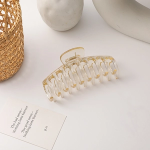 Detail view of a large translucent resin hair claw clip with golden metal spring