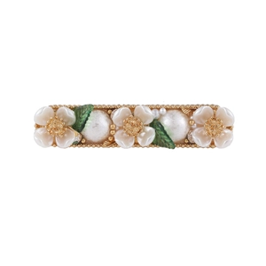 Detail of floral hair clip with white shell flowers, pearls and green leaves on gold base