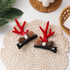 Detail von Weihnachts-Rentier-Haarspangen mit Pinienzapfen und weichen Plüschbällen