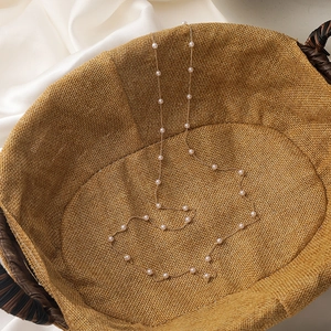 Detail of elegant gold eyewear chain with white pearls on vintage woven basket background