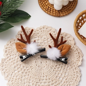 Detail von Weihnachts-Rentier-Haarspangen mit Plüschbommeln und Geweih auf Spitzenmatte