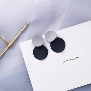 Detail of matte geometric earrings with blue and grey double circular overlapping design