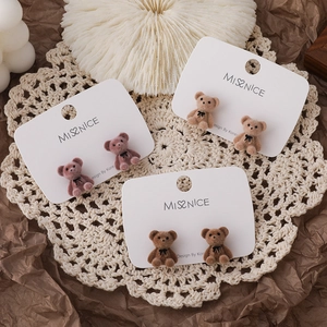 Three pairs of flocking bear stud earrings in pink and brown on a jewelry card