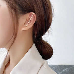 Detail of elegant gold ear cuff with shimmering micro-pave cubic zirconia on female model