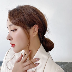 Minimalist gold ear cuff with sparkling zircon stones worn by model on ear cartilage