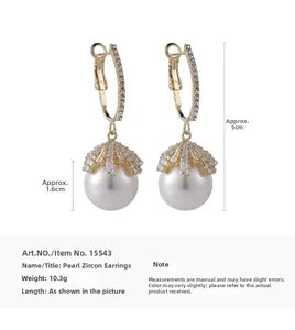 Detail view of gold pearl earrings with zircon stones showing 5cm length and 1.6cm width