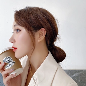 Detailed view of a gold 'love' letter ear crawler worn on a model in a lifestyle setting