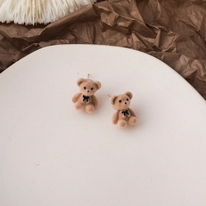 Detailed view of cute brown flocked bear earrings with black bowknot accents