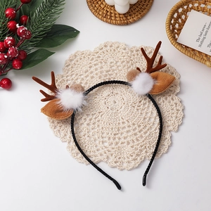 Detail von Weihnachts-Rentier-Geweih-Stirnband mit Plüschbällen auf Spitzenmatte