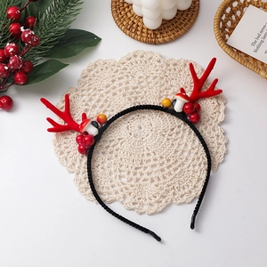 Detailansicht eines Weihnachts-Rentier-Hairreifens mit Geweihen, Beeren und Pilzen