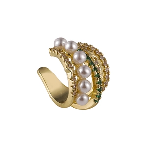 Détail du ear cuff doré orné de perles blanches, zircons verts et d'étoiles