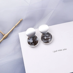 Detail of round geometric silver earrings with grey marble texture on white card