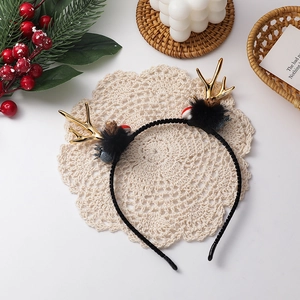 Detailaufnahme von Weihnachts-Haarreif mit goldenem Rentiergeweih und Tannenzapfen