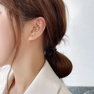 Close-up of minimalist gold ear cuff climber featuring five sparkling zircon stones on a model