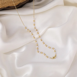 Elegante goldene Brillenkette mit Perlen und Kristallakzenten auf weißem Seidenhintergrund