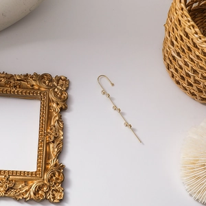 Detailed close-up of a gold-plated ear cuff with five sparkling square-cut zircons