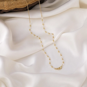 Detailansicht der eleganten goldenen Brillenette mit Perlen und Kristallen auf Seide