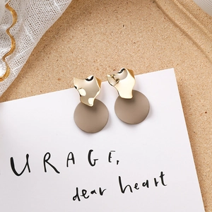 Gros plan détaillé de boucles d'oreilles en acrylique brun avec accents dorés géométriques