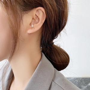 Close-up of gold ear cuff with marquise zircon stone on ear, minimalist modern chic style