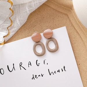 Détail de boucles d'oreilles en acrylique rose et marron aux tons Morandi chauds